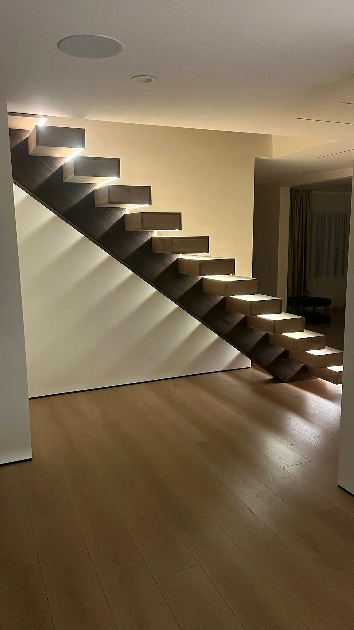 Floating staircase illuminated with a softer ambient night scene